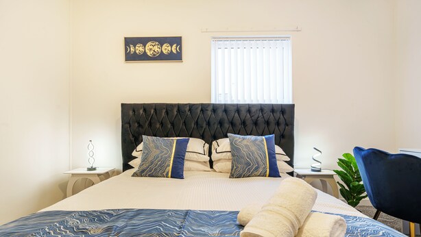 A neatly made bed with a patterned bedspread, a headboard, and decorative pillows. - Next to Liverpool station stadium city (Liverpool)
