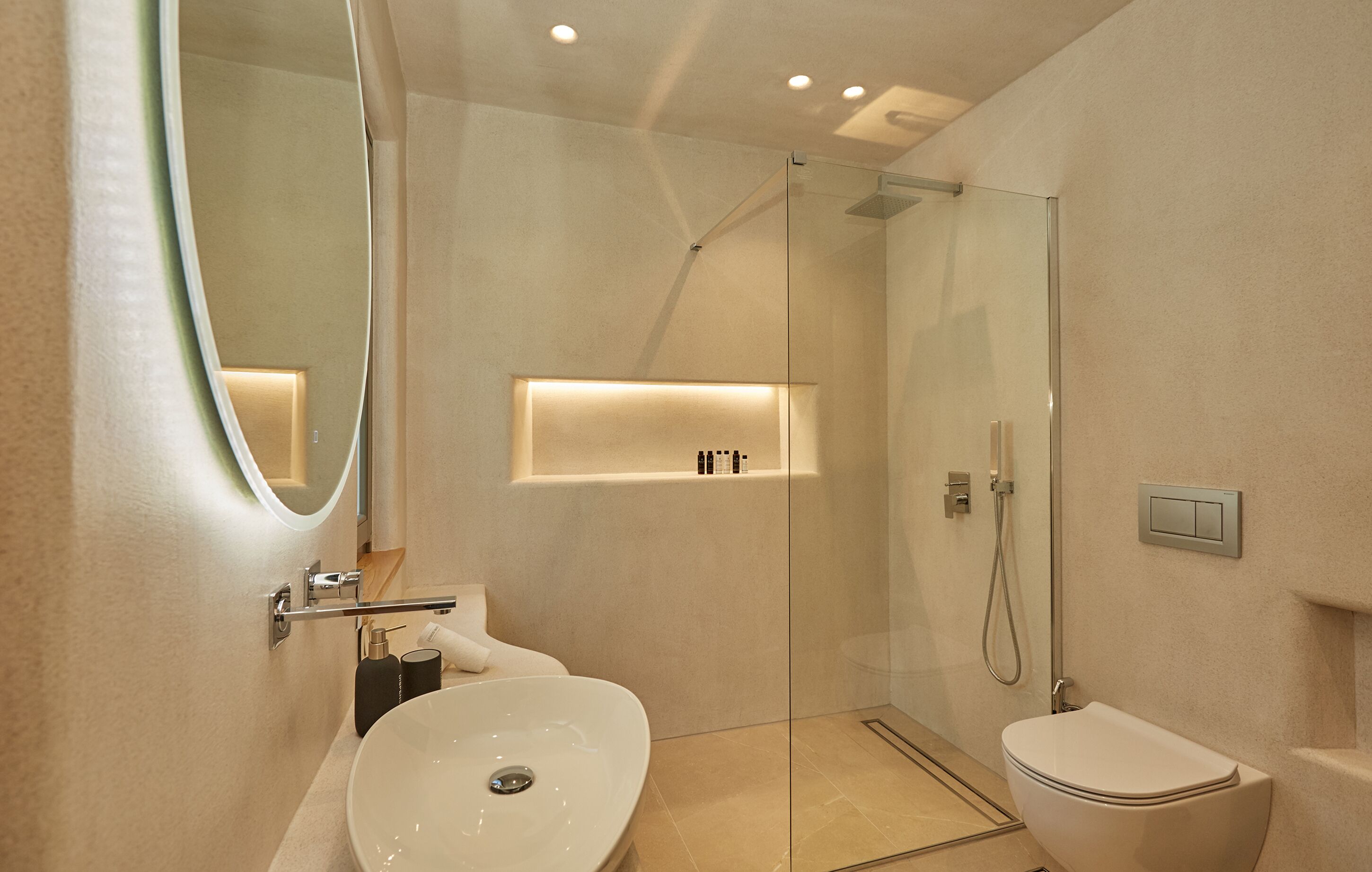 A modern bathroom with a glass-enclosed shower, a white sink, and a toilet.