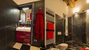 A bathroom with a checkered floor, a bidet, a toilet, and a shower with a glass door. - Suite Apartment 2/4 Persons (Firenze)