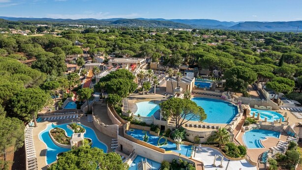 Un complexe hôtelier doté de plusieurs piscines, d’un toboggan aquatique et offrant une vue sur le paysage environnant.