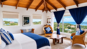 Un dormitorio con cama, dos sillas, una mesa y vistas al paisaje.