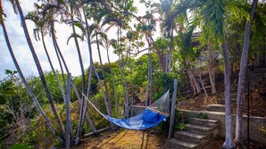 A hammock in a natural setting with trees and a stone staircase. - Charming Cottage Located In Cap Estate - Orchid Cottage 1 Bedroom Home by RedAwning (Gros Islet)