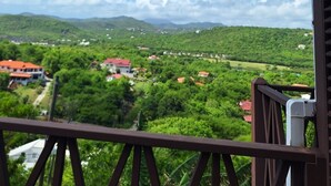 A balcony with a view of a green landscape and distant buildings. - Charming Cottage Located In Cap Estate - Orchid Cottage 1 Bedroom Home by RedAwning (Gros Islet)