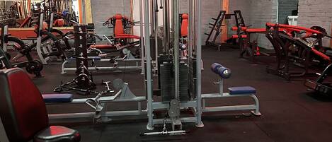 A gym with various exercise equipment, including weight machines and benches.