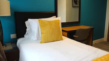 Une chambre d’hôtel avec un lit, un bureau et une chaise.