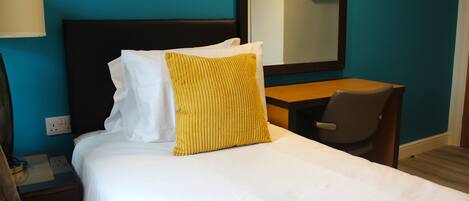 A hotel room with a bed, a desk, and a chair.