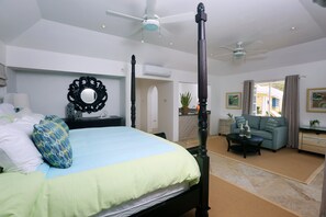 A spacious bedroom with a large bed, a sitting area with a sofa and coffee table, and a balcony with curtains. - 2-bed Villa With Uninterrupted Sea Views - Equinox 2 Bedroom Villa by RedAwning (Gros Islet)