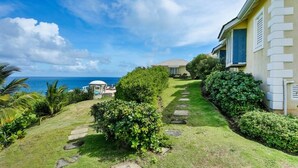 A coastal property with a well-maintained lawn, stone pathway, and a view of the ocean. - 2-bed Villa With Uninterrupted Sea Views - Equinox 2 Bedroom Villa by RedAwning (Gros Islet)