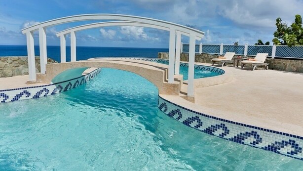 A swimming pool with a white archway, surrounded by lounge chairs and a view of the ocean. - 2-bed Villa With Uninterrupted Sea Views - Equinox 2 Bedroom Villa by RedAwning (Gros Islet)