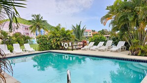 A swimming pool with white lounge chairs and palm trees. - Bay View #7 - 3 bedroom, 3.5-bath waterfront townhouse in a gated community in Rodney Bay 3 Townhouse by RedAwning (Gros Islet)