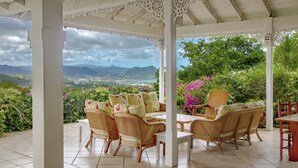 A covered patio with wicker furniture, a view of a mountainous landscape, and lush greenery. - Zephyr Hill - 2 bedroom Villa with awe inspiring views 2 Villa by RedAwning (Gros Islet)