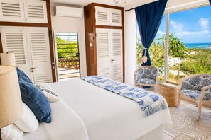 A bedroom with a bed, a chair, a view of the sea, and a balcony. - Hilltop Villa With Great Views Out To Sea - Villa Cadasse 3 Bedroom Villa by RedAwning (Gros Islet)