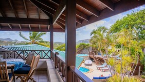 A covered outdoor area with a pool, lounge chairs, and a view of the landscape. - Hilltop Villa With Great Views Out To Sea - Villa Cadasse 3 Bedroom Villa by RedAwning (Gros Islet)