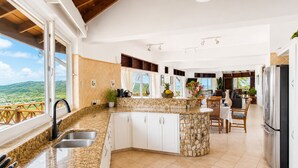 A kitchen with a stone island, white cabinets, and a view of the outdoors. - Hilltop Villa With Great Views Out To Sea - Villa Cadasse 3 Bedroom Villa by RedAwning (Gros Islet)