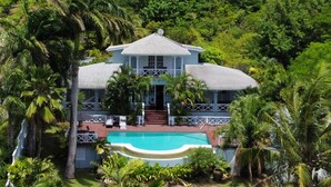 A large house with a swimming pool surrounded by lush greenery. - Beautiful Caribbean Style 2-bed Family Villa - Villa Kessi 2 Bedroom Villa by RedAwning (Gros Islet)