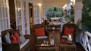 A cozy lounge area with wicker furniture, a fireplace, and a view of lush greenery. - Beautiful Caribbean Style 2-bed Family Villa - Villa Kessi 2 Bedroom Villa by RedAwning (Gros Islet)