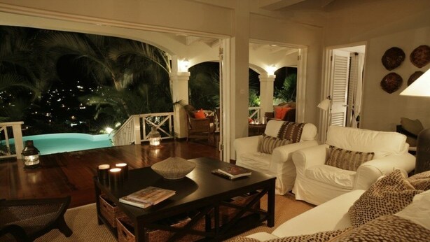 A cozy living room with a pool view, white furniture, and a wooden coffee table. - Beautiful Caribbean Style 2-bed Family Villa - Villa Kessi 2 Bedroom Villa by RedAwning (Gros Islet)