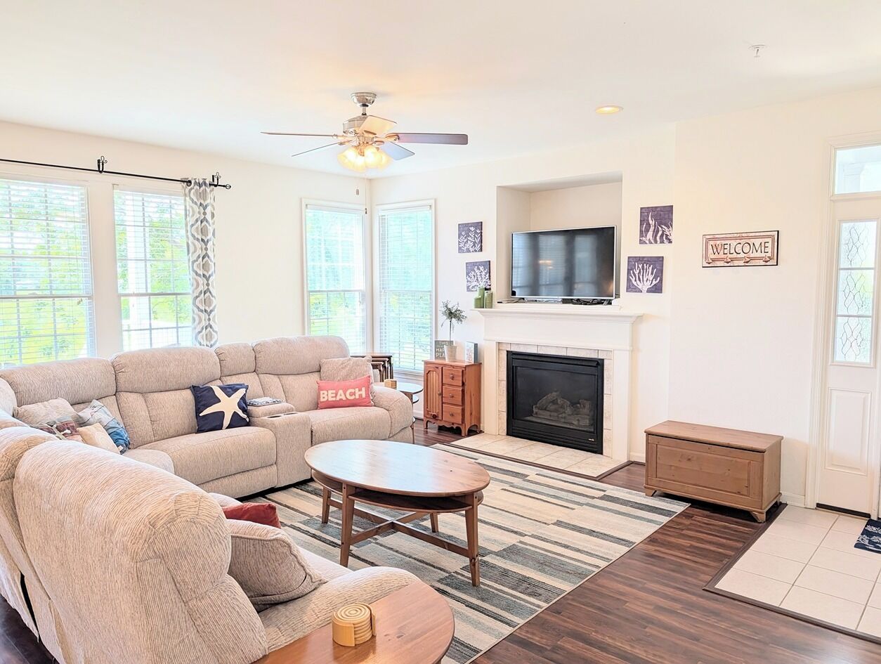 A living room with a sofa, a round coffee table, a fireplace, and a television.