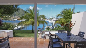 A terrace with a view of a marina, outdoor seating, and a water feature. - The Anchorage #5 a 2 bedroom Waterfront Condo in Rodney Bay 2 Condo by RedAwning (Gros Islet)