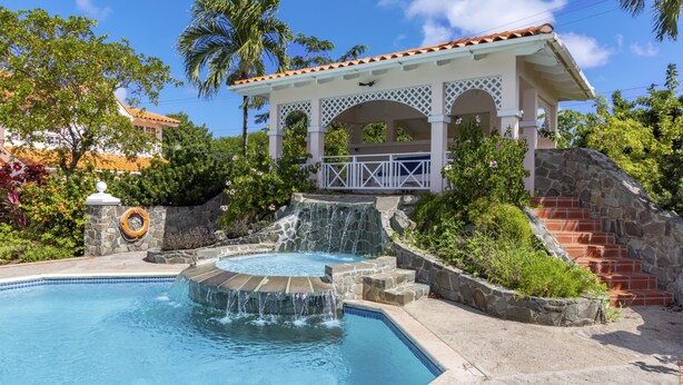 A swimming pool with a waterfall feature, a gazebo, and a stone staircase. - The Anchorage #5 a 2 bedroom Waterfront Condo in Rodney Bay 2 Condo by RedAwning (Gros Islet)