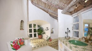 A bathroom with a green sink, white tiles, a potted plant, and a window. - Smuggler's Nest - Exotic & Romantic Villa 2 Bedroom Villa by RedAwning (Gros Islet)