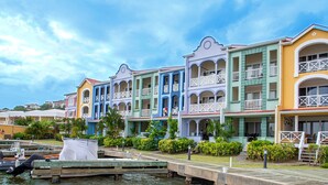 A row of colorful buildings with balconies and a dock with boats.
