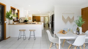 Enjoy meals in this open-plan kitchen and dining area, featuring a central island and dining table for two.
