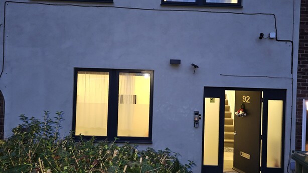 A two-story building with a flat facade, large windows, and a door marked with the number 92. - 1 Bed Flat - Sleeps 2 - Parking - Garden (London)