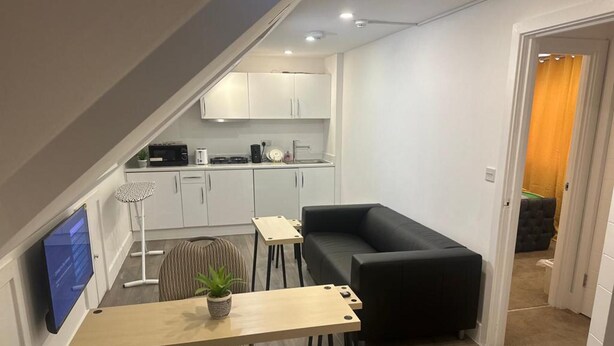 A compact living space with a kitchenette, a dining area, and a seating area. - 1 Bed Flat - Sleeps 2 - Pets - Garden - Parking (London)