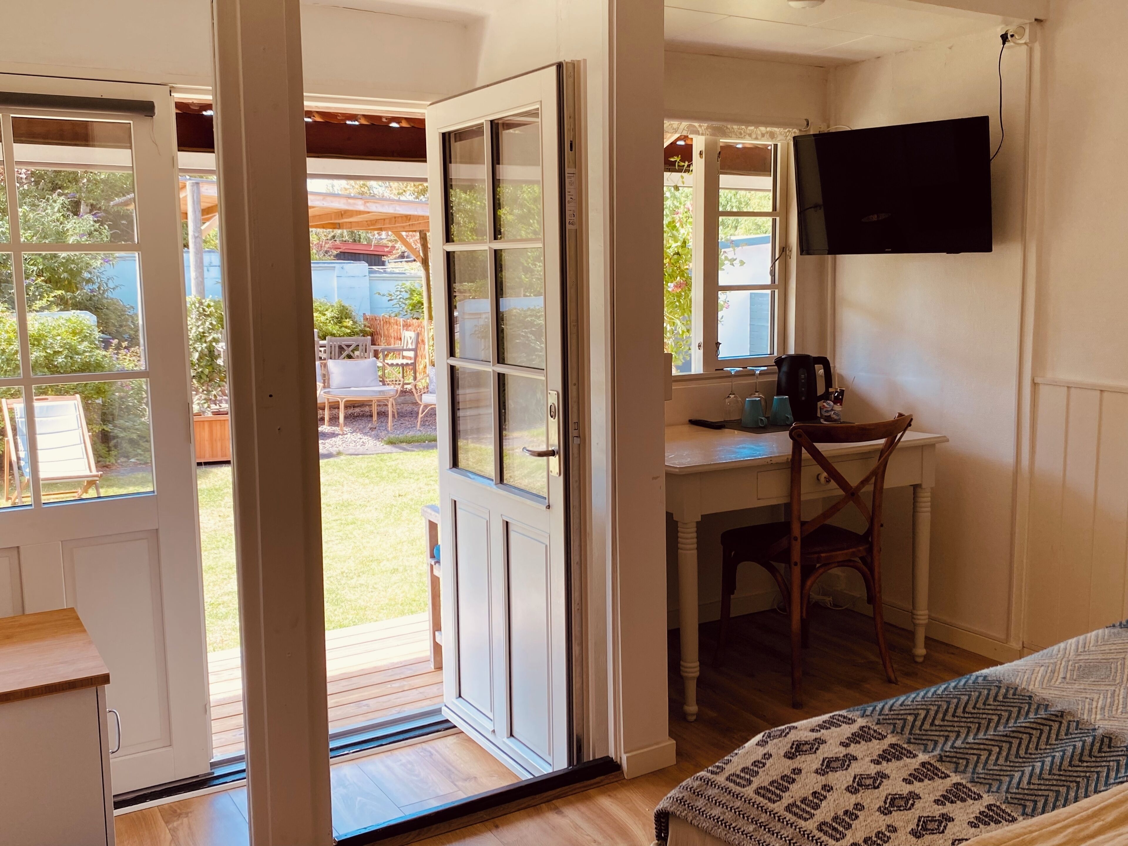 Una habitación con escritorio, silla, cama y televisión.