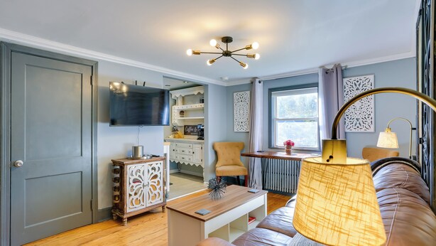 Una sala de estar moderna con un sofá de cuero, una mesa de centro de madera y un televisor montado en la pared.