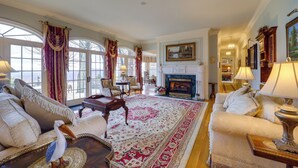 A spacious living room with a large rug, comfortable seating, and a fireplace. - Immaculate Boone Villa w/ Entertainment Lounge! (Boone)