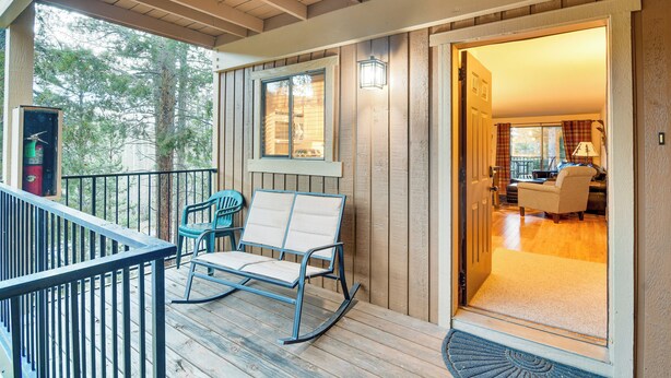 A wooden deck with a rocking chair and a chair, a door leading inside, and a view of the outdoors. - Condo w/ Pool Access: 2 Mi to Winter Park Resort! (Winter Park)