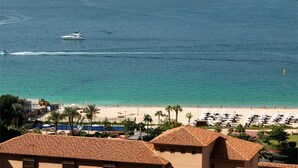 A coastal view with a beach, boats, and a clear sky.