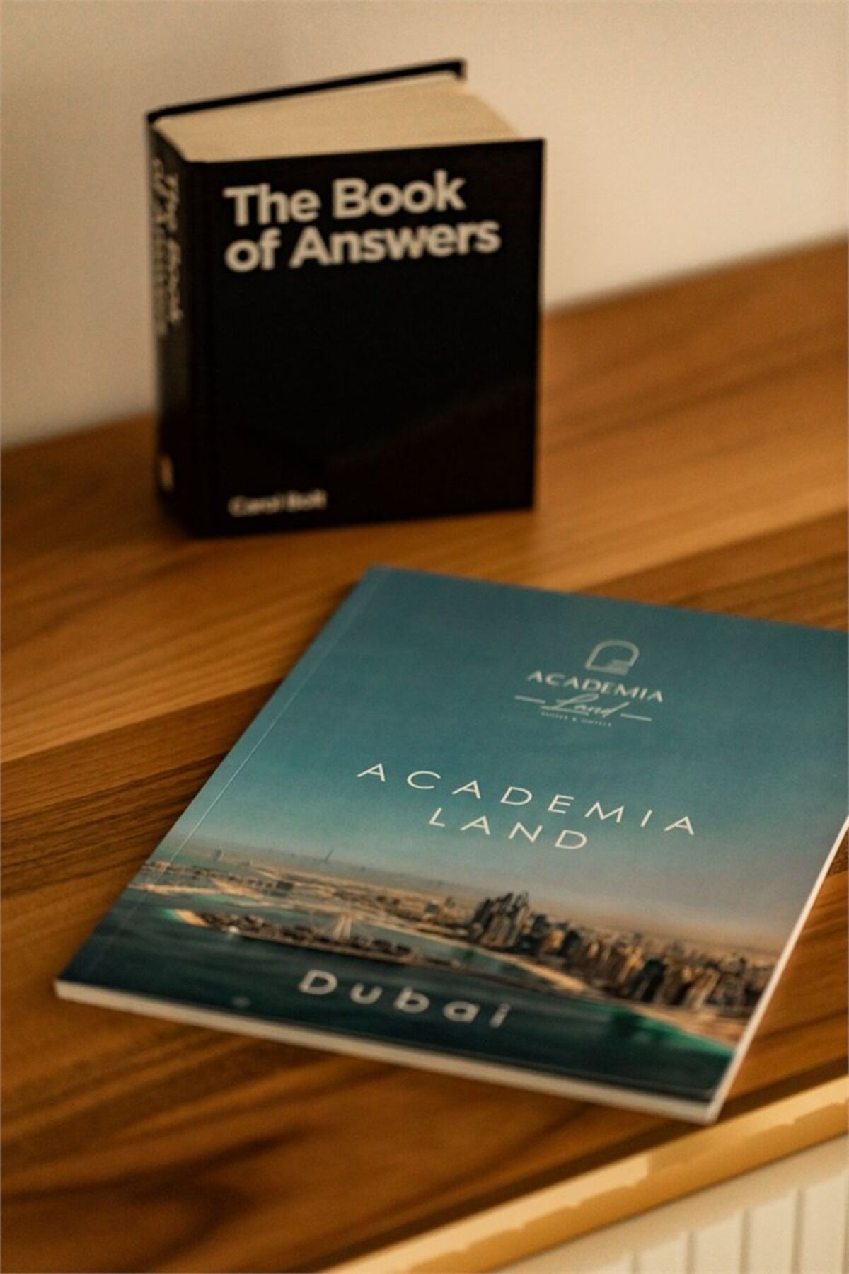 A book titled "The Book of Answers" on a wooden surface.