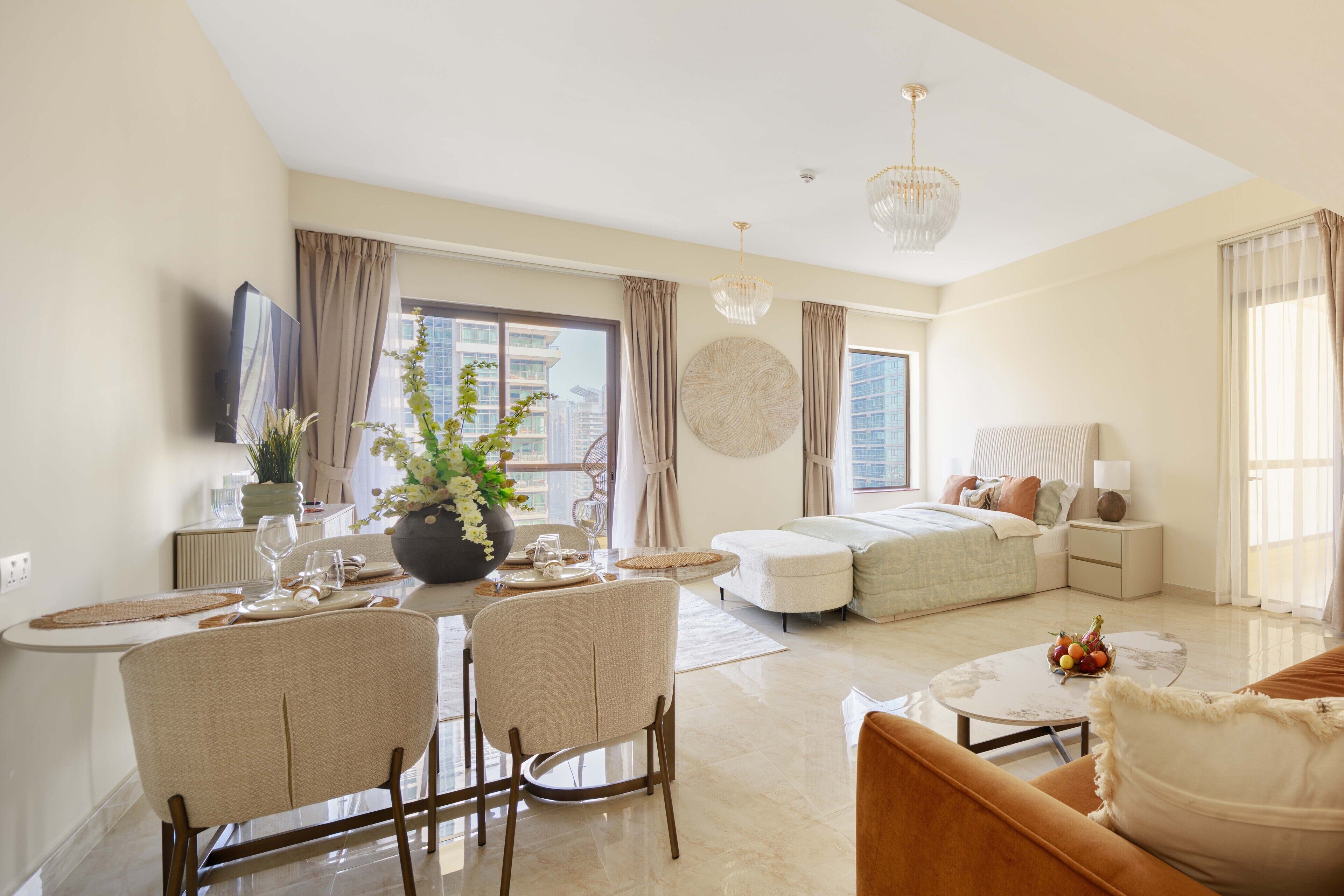 A modern living room with a dining area, a sofa, a coffee table, and a bed.