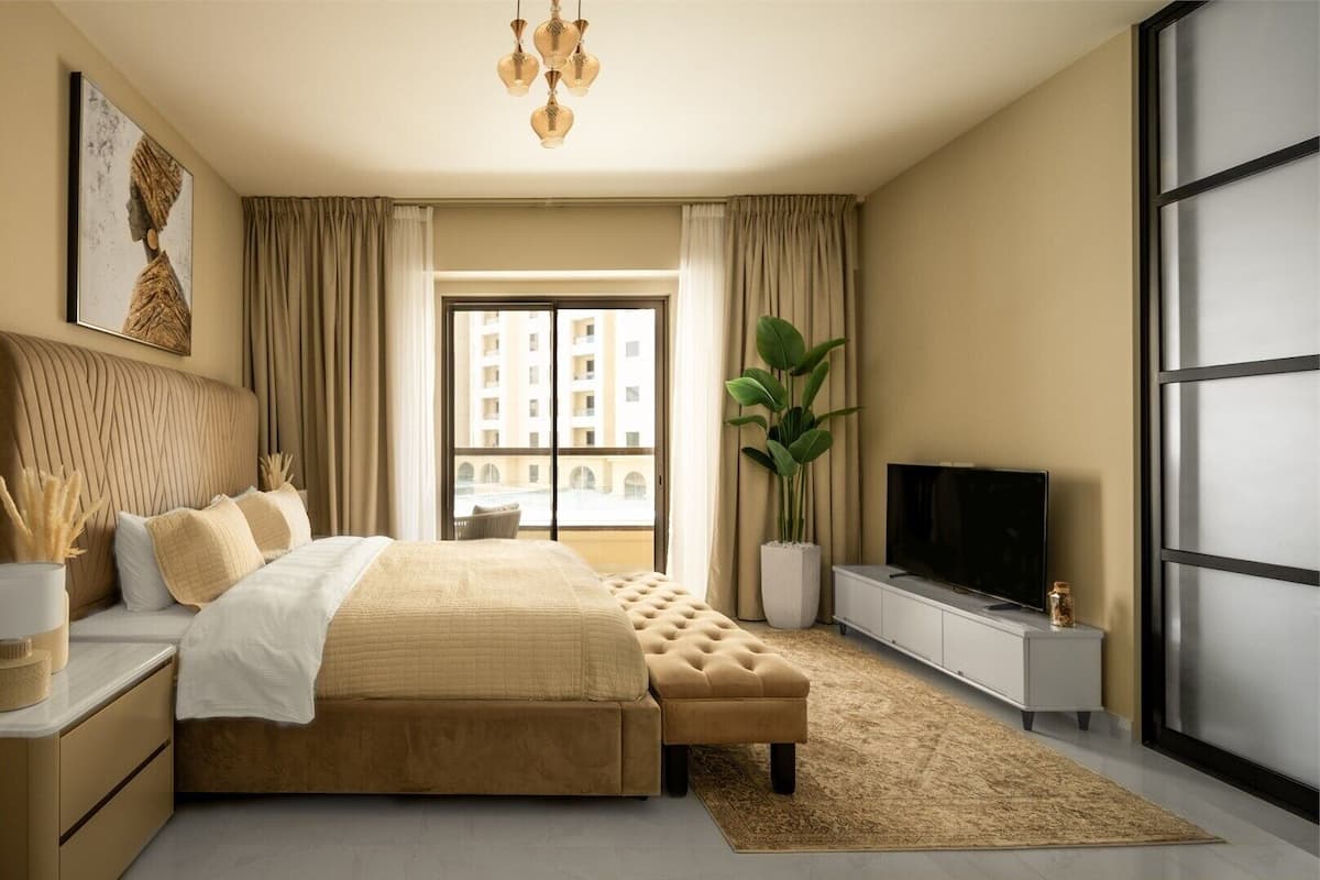 A modern bedroom with a large bed, a television, a plant, and a view of the city through the window.