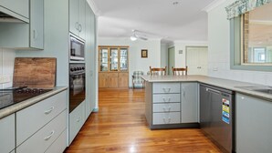 Una cocina moderna con armarios de madera, horno empotrado y lavavajillas.
