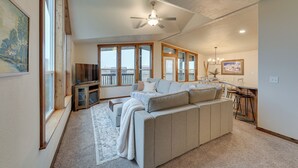 A spacious living room with a large sofa, a ceiling fan, and a dining area with a table and chairs. - Beautiful Tetonia Escape w/ Porch & Teton Views (Tetonia)