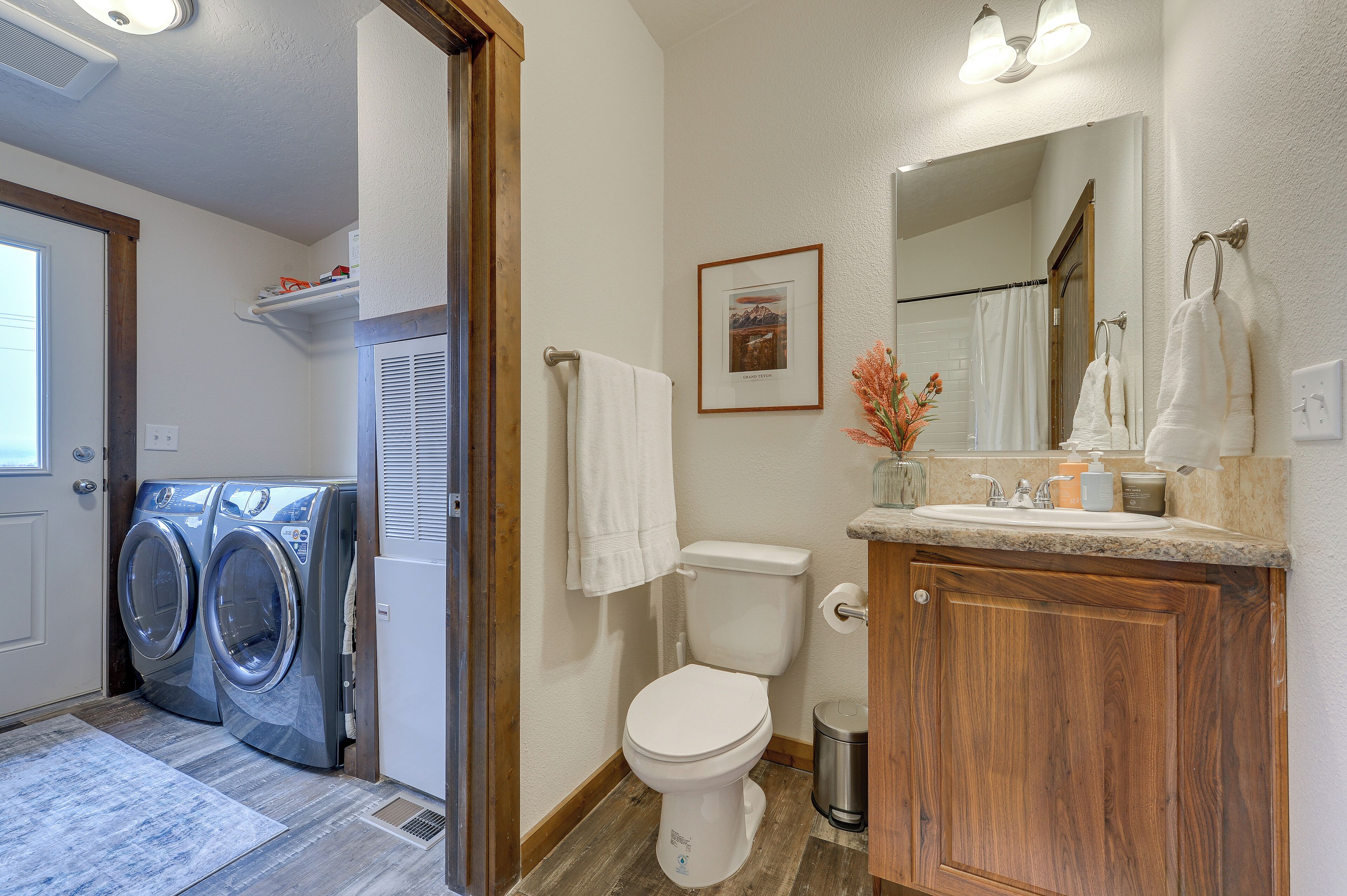 A compact bathroom with a toilet, sink, and two wall-mounted washing machines.