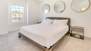 A bedroom with a bed, a nightstand, and three wall-mounted mirrors. - 12 Mi to Dtwn Austin: Quiet Home w/ Patio & Yard (Del Valle)