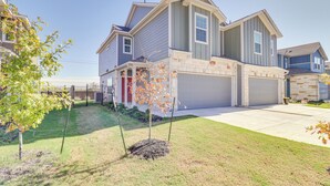 A two-story house with a garage, a well-maintained lawn, and a tree in the front yard. - 12 Mi to Dtwn Austin: Quiet Home w/ Patio & Yard (Del Valle)