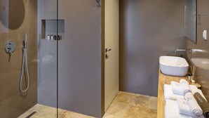 A modern bathroom with a glass-enclosed shower, a wooden vanity with a sink, and a mirror. - Two-bedroom Villa with a private heated pool (Thasos)