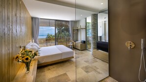 A modern bedroom with a large bed, a glass shower enclosure, and a view of the outdoors. - Two-bedroom Villa with a private heated pool (Thasos)