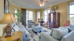 A living room with a ceiling fan, a sofa, a loveseat, a small table, and a cabinet.