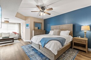 Ein Schlafzimmer mit Bett, Nachttisch und Deckenventilator.
