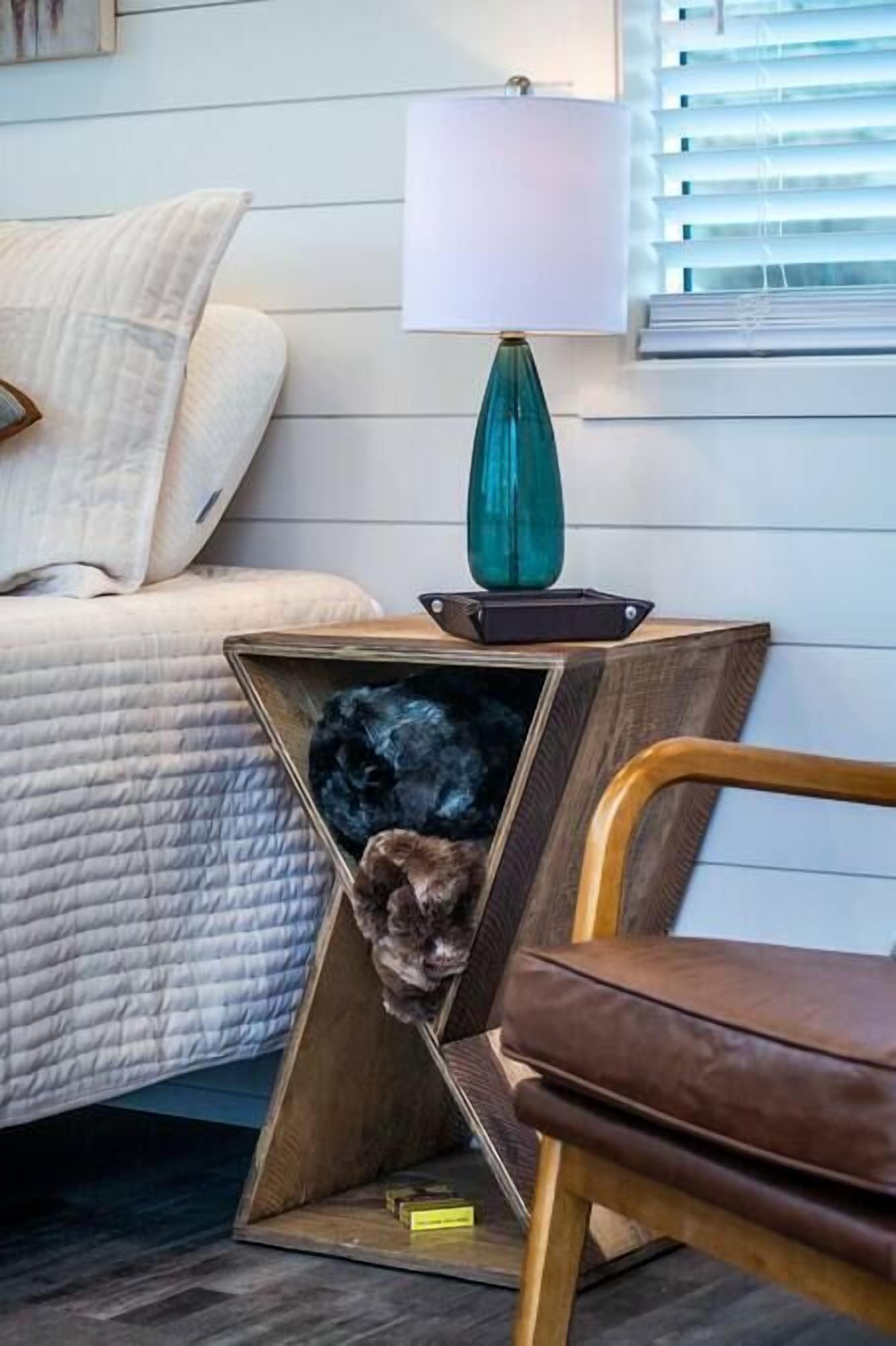 Une chambre à coucher avec un lit, une table de chevet avec une lampe et une chaise.