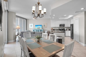 A modern kitchen with white cabinets, a microwave, and a refrigerator. - Lighthouse 404 | 3BR Gulf-Front + Resort Pools (Gulf Shores)