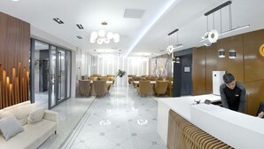 A modern hotel lobby with a reception desk, seating area, and a large window. - Qaragat (Jalal-Abad)