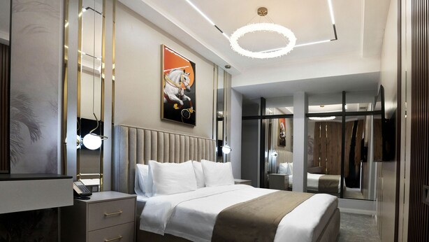 A modern hotel room with a large bed, a desk, and a wardrobe. - Qaragat (Jalal-Abad)